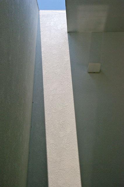 <p>Light falls down the painted white walls</p>