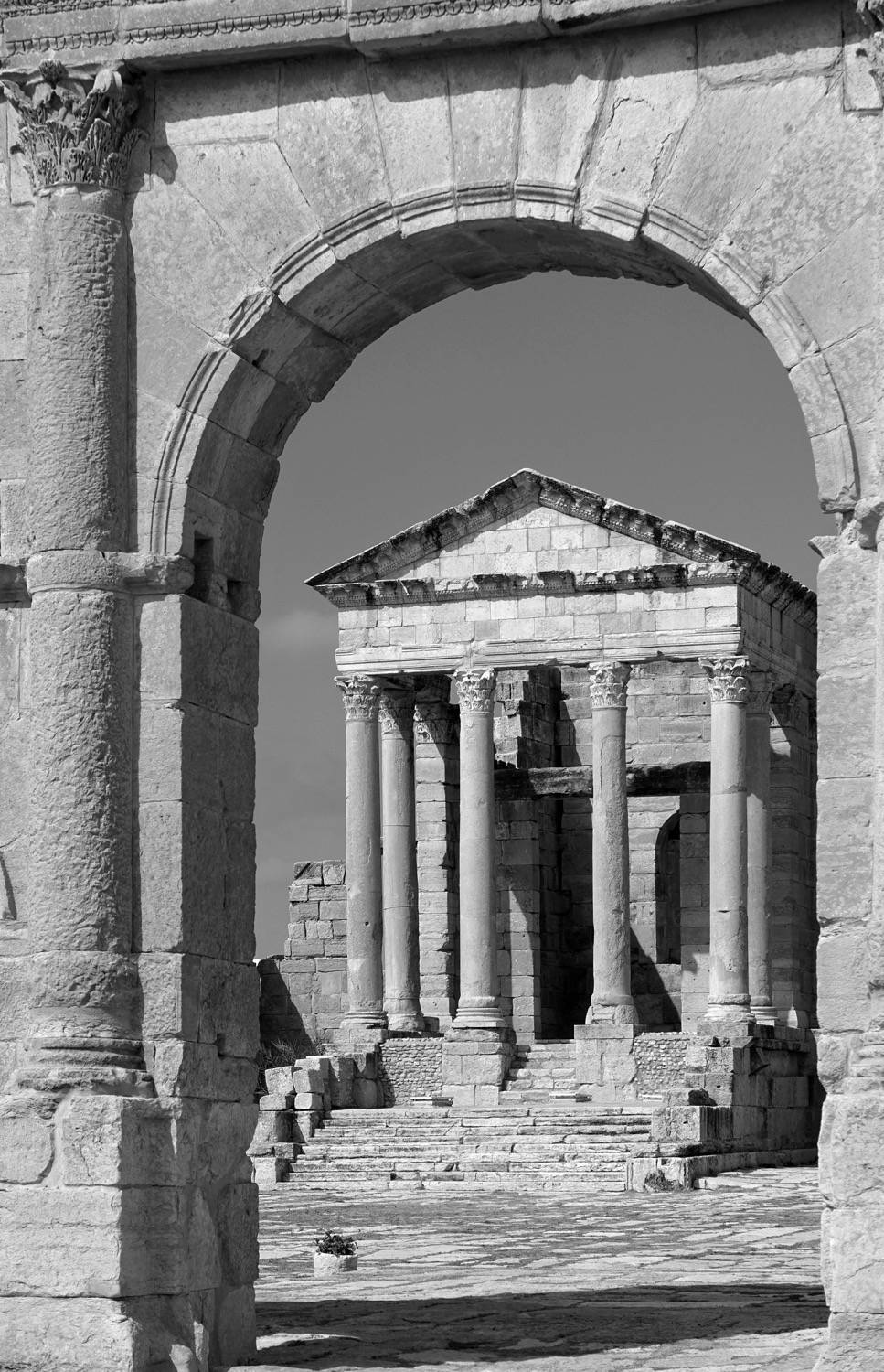 View of facade of the Temple of Juno; Arch of Antoninus Pius in the forefront. 