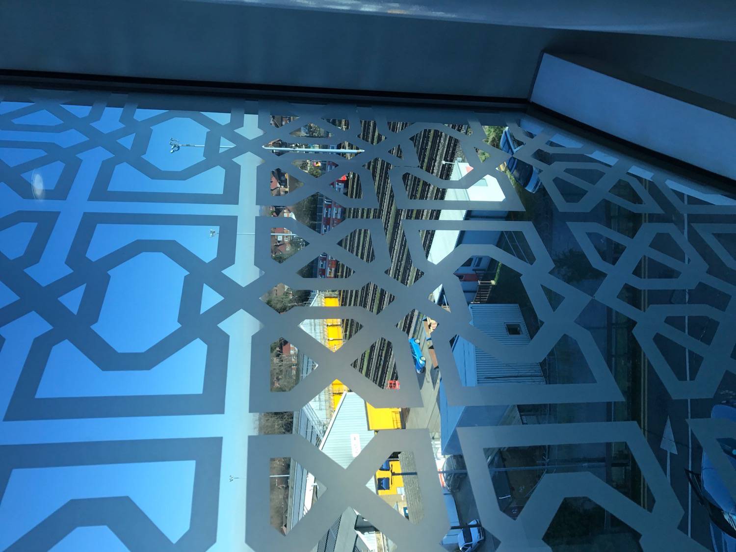 View through a window decorated with geomatric patterns to the neighboring railyard