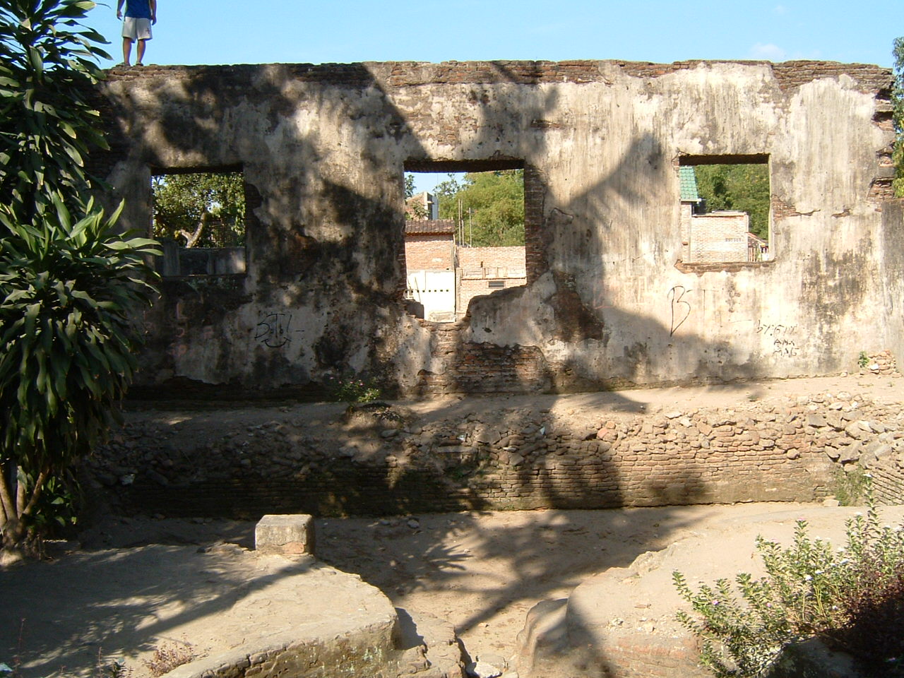 View looking east over pool at doorway flanked by two windows