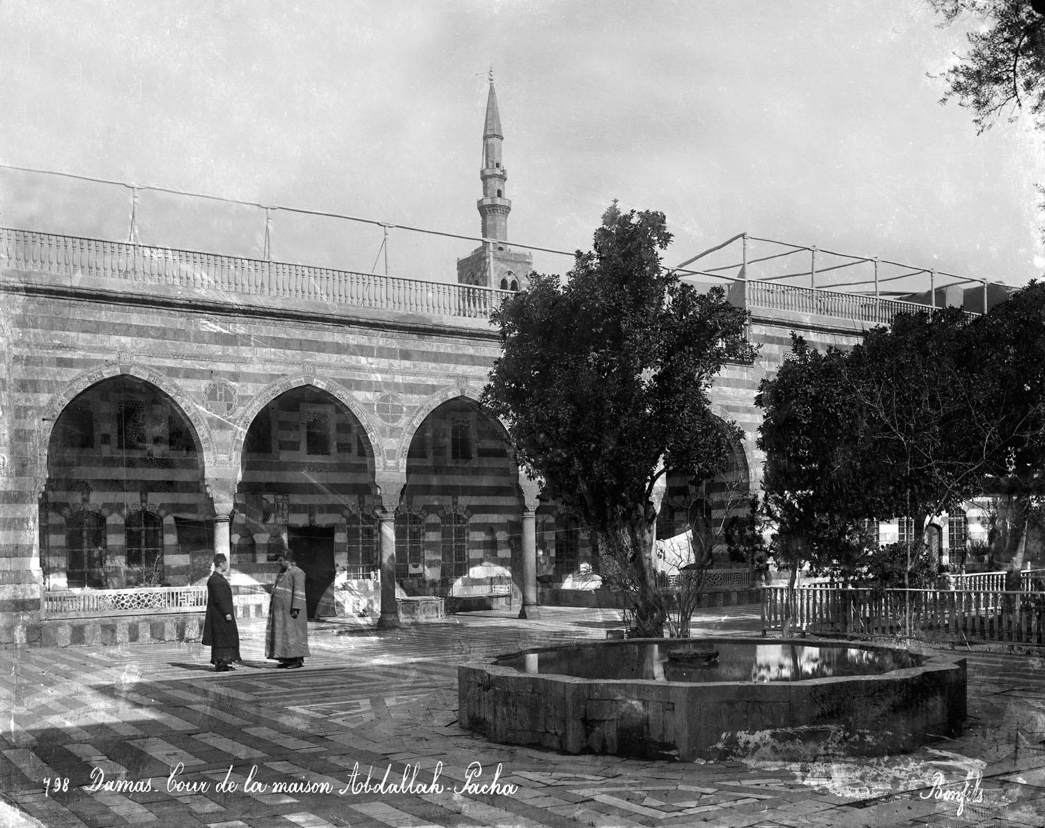 View of ablaq courtyard with fountain, arcade, and garden