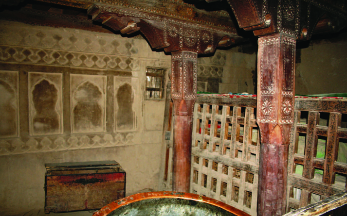 Interior of the ziarat showing the enclosure, carved timber posts and plaster work on the southern wall