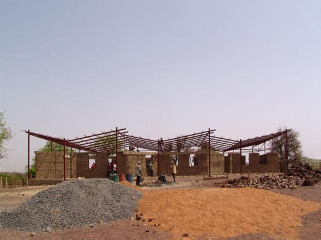 People of the village elevating the wall in "stabilized soil block"