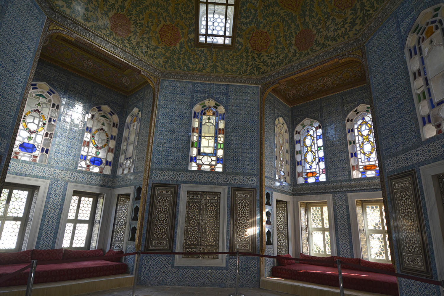 Interior view of the Revan Köşkü, capturing the elaborate interior ornamentation, including Iznik tiles, inlaid cabinets and floral painted dome.