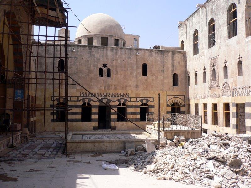 View of the courtyard toward the qubba, with rubble and scaffolding