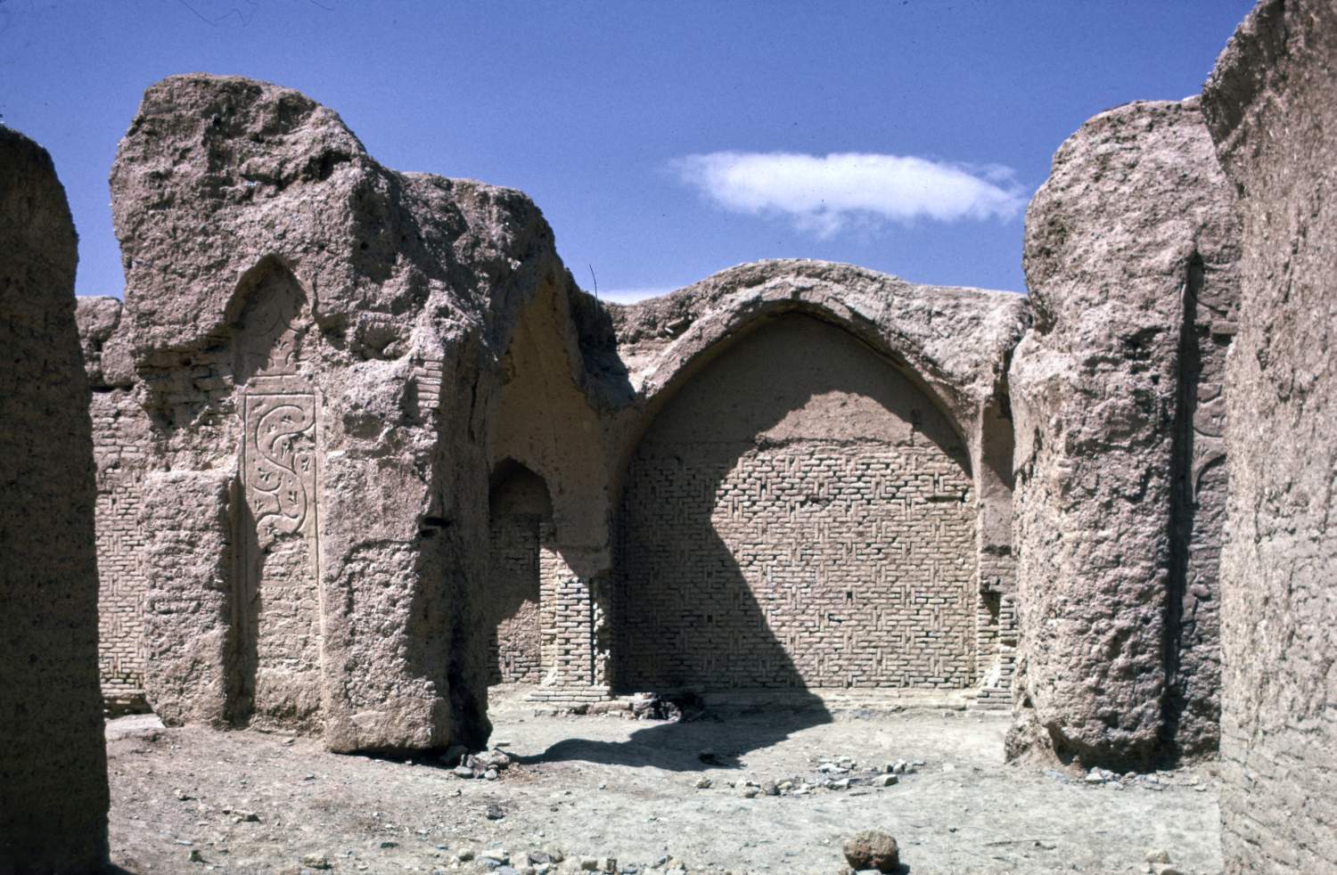 View toward southwestern enclosure wall (qibla wall) showing baked brick masonry and remnants of piers and arches in foreground.