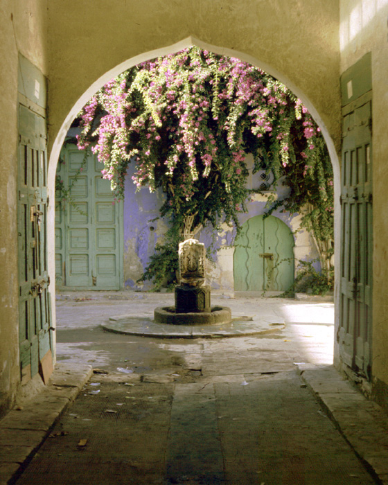 <p>View through a covered street to a fountain</p>