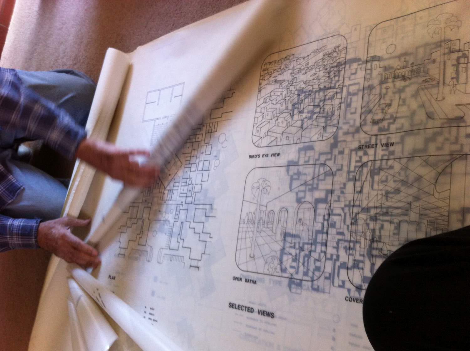 Besim Hakim unrolling several illustrations and urban planning maps from his work in Tunis in the 1970s, in Albuquerque, New Mexico, October 2017.