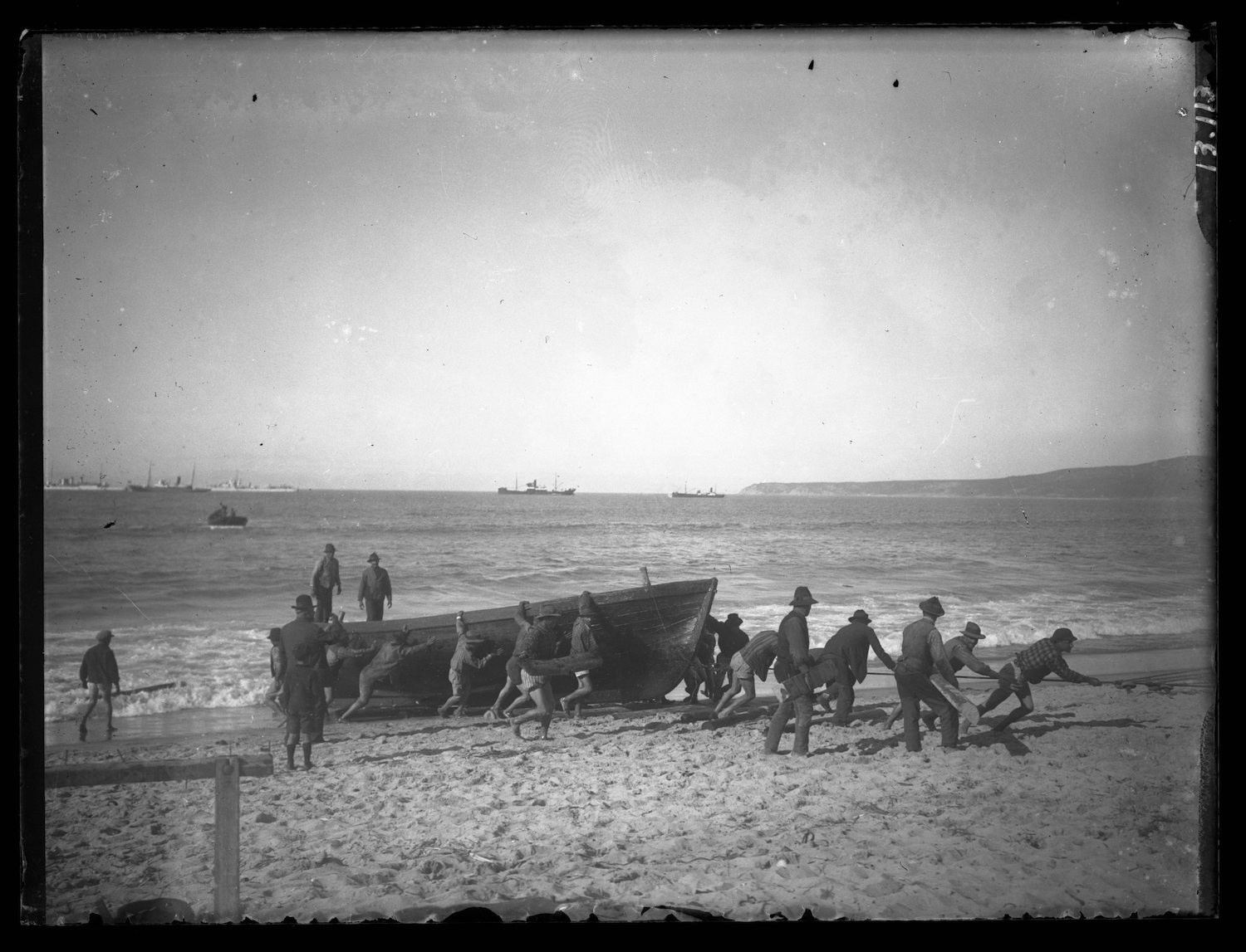 <p>Fishermen pulling in a boat</p>