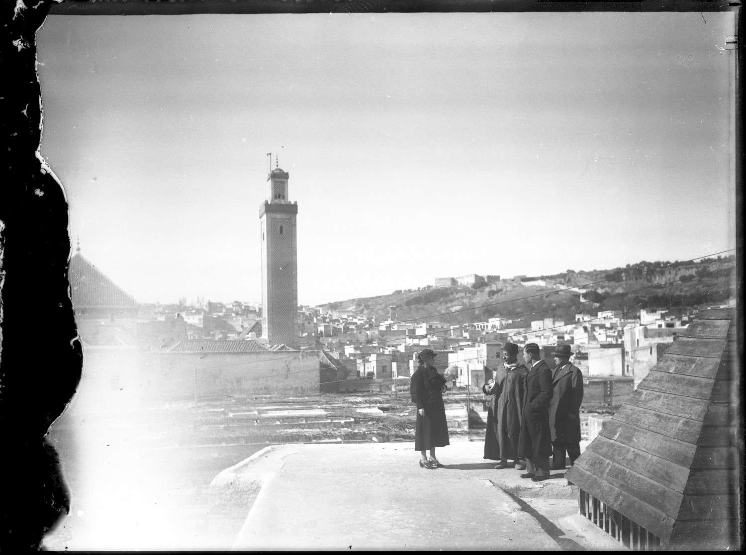 Jami' al-Qarawiyyin - The minaret of Jami' al-Qarawiyyin, with a group of men in the foreground.