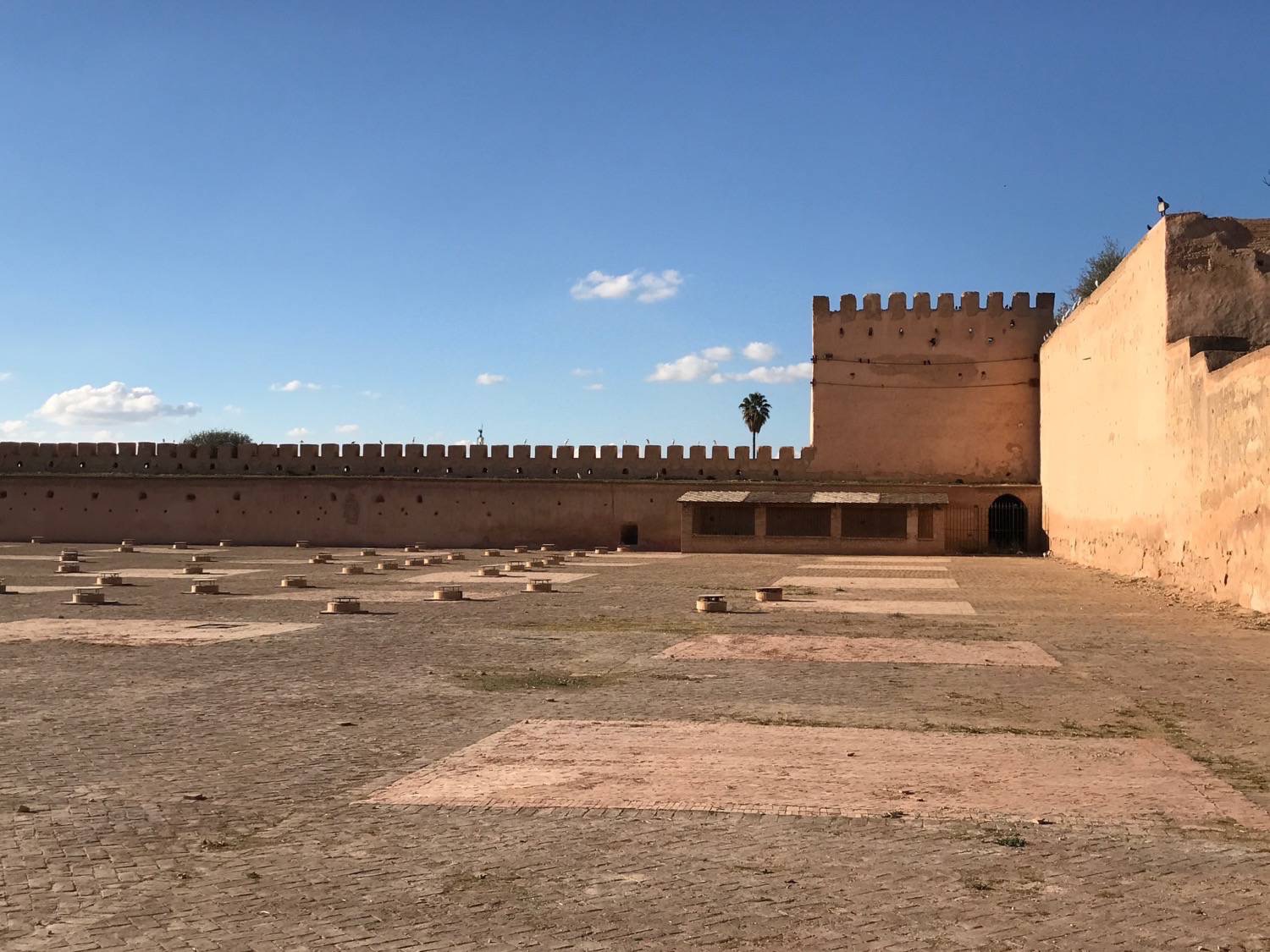 A section of the large plaza inside Moulay Ismail's complex.  This part shows one corner of the fortified remparts protecting this section of the city.  It also shows one of the  watch towers.  The circular structures punctuating the plaza are ventilation ducts for the prison cells below.  